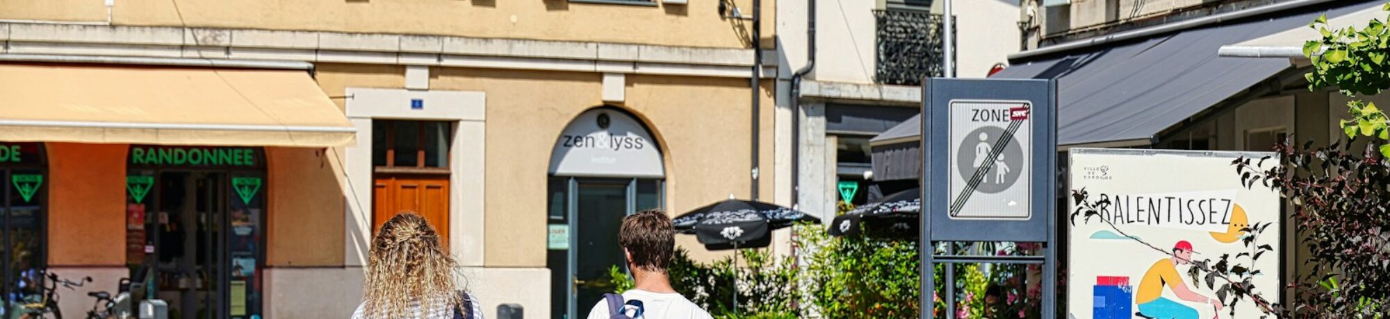 A couple of people walking down a street